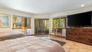 A bedroom with two beds, a TV, and a sliding glass door leading to a balcony. - Large East Vail Home - Hot Tub & Steps to Bus Stop (Vail)