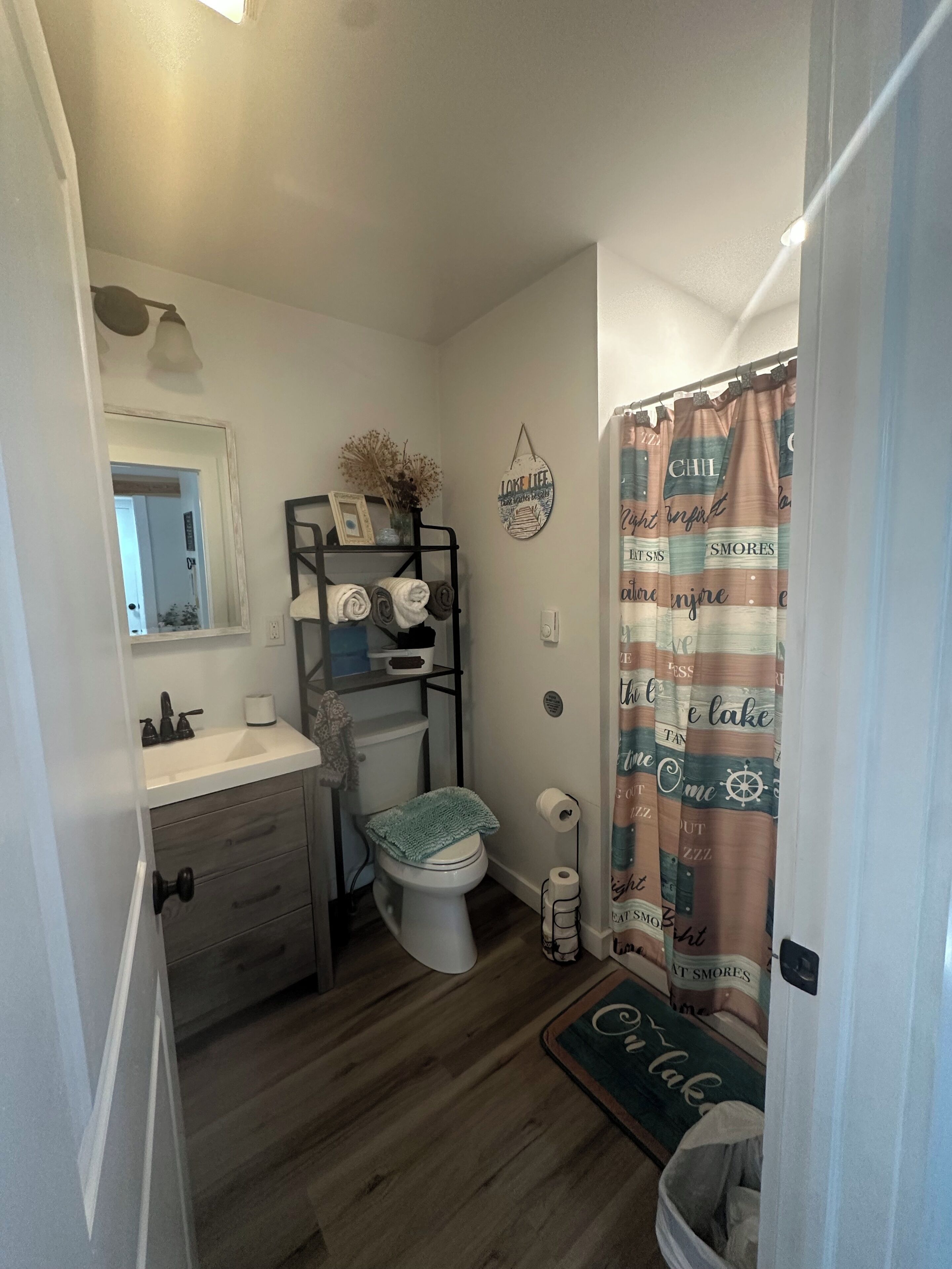 Ein kleines Badezimmer mit Toilette, Waschbecken und Handtuchhalter.