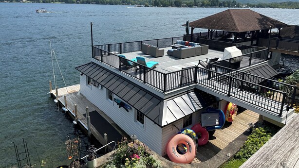 Propiedad frente al agua con terraza, mobiliario exterior y muelle.