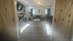 Una sala de estar con un sofá, una mesa de centro y un televisor.