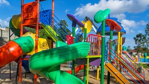 Un patio de juegos colorido con diversas resbaladillas y estructuras para escalar.