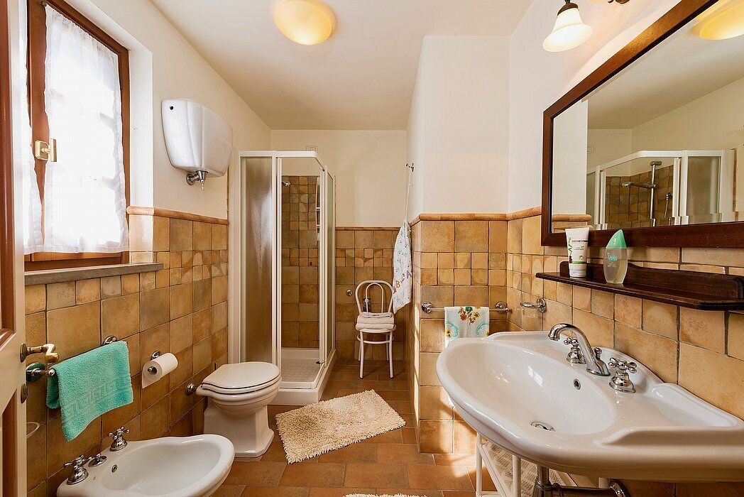 Ein Badezimmer mit Toilette, Bidet, Waschbecken und Dusche.