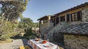 A stone building with a dining area set up outside.