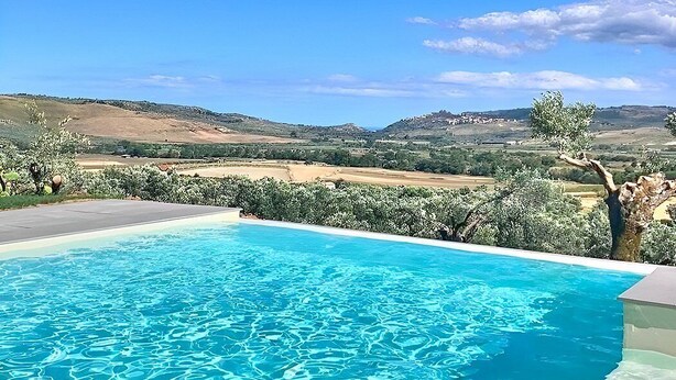 A swimming pool with clear blue water, surrounded by greenery and hills in the background. - Villa Bougainville: A welcoming one-story villa situated in a quiet location, a few minutes from the town center, with Free WI-FI. (Amaroni)