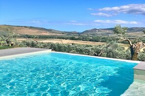 A swimming pool with clear blue water, surrounded by greenery and hills in the background. - Villa Bougainville: A welcoming one-story villa situated in a quiet location, a few minutes from the town center, with Free WI-FI. (Amaroni)