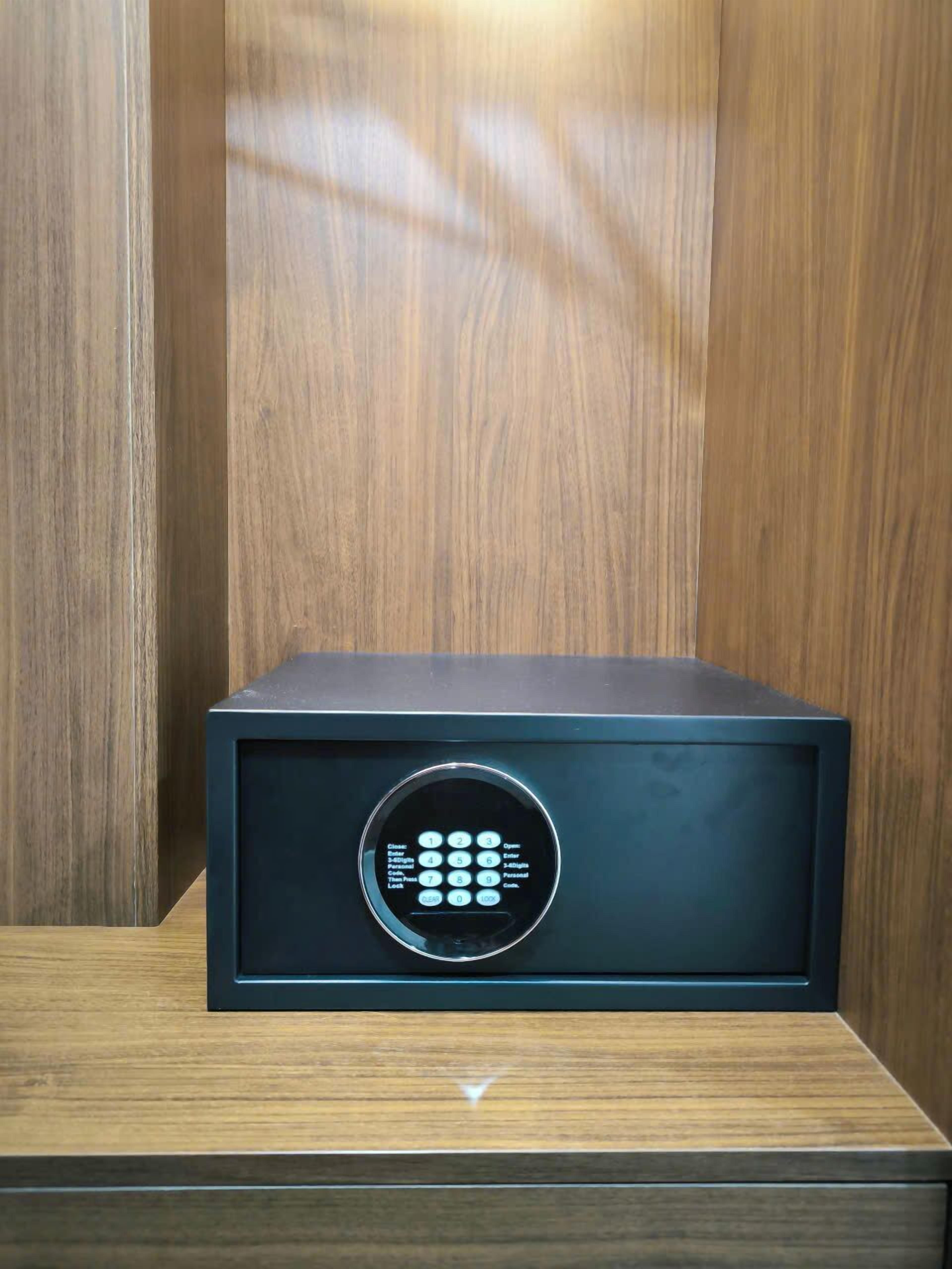 A black safe with a keypad on a wooden surface.