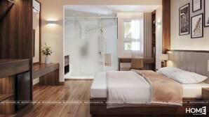 Una habitación de hotel moderna con una cama grande, un vestidor amplio, cabina de ducha de vidrio y vistas al exterior.