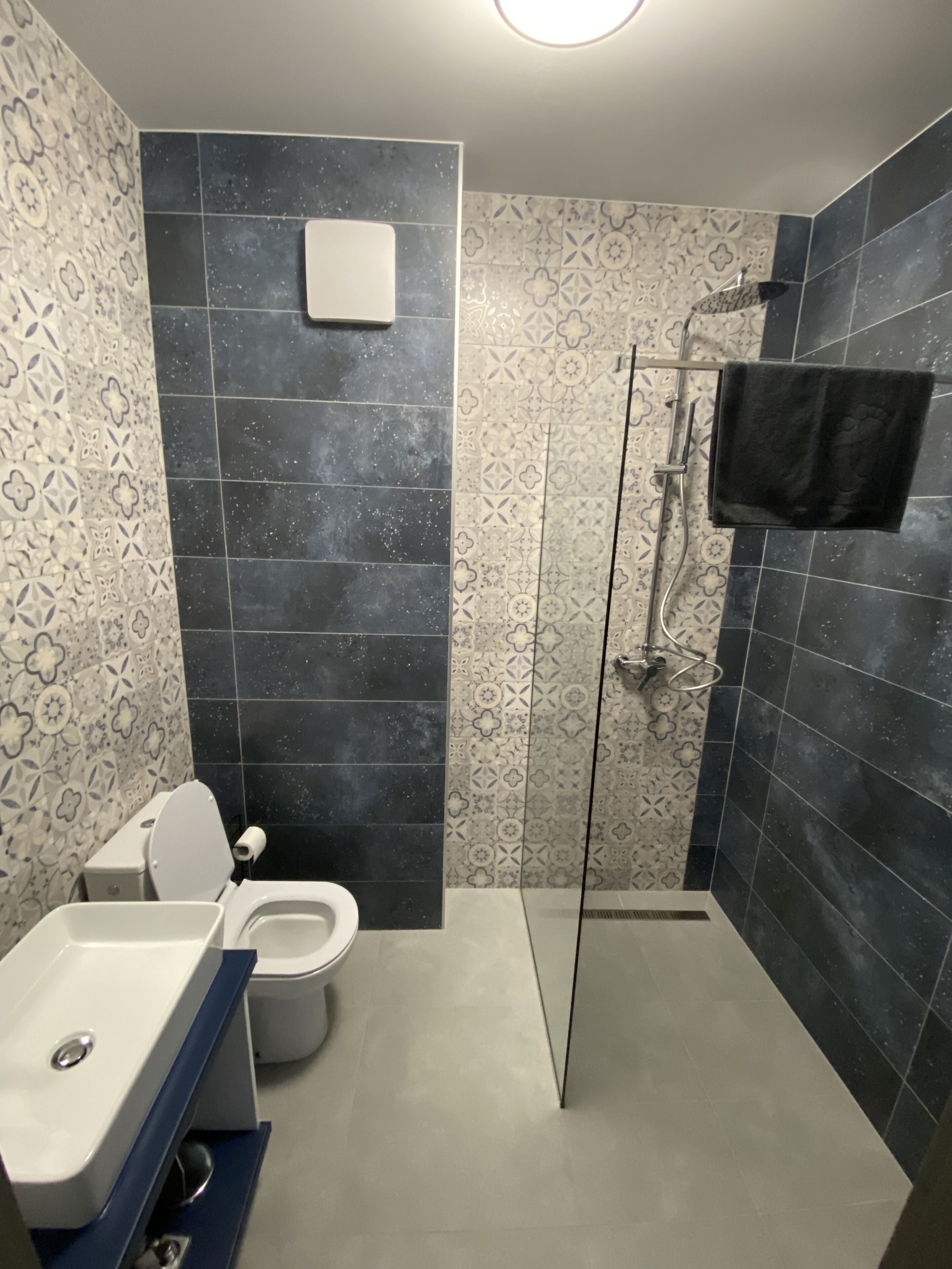 Un baño con inodoro, lavamanos y zona de ducha.
