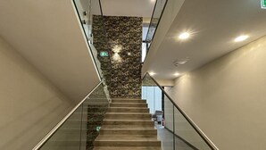 Una escalera moderna con barandillas de vidrio y un revestimiento con diseño en la parte superior.