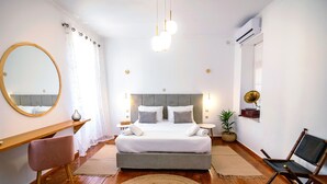 Un dormitorio moderno con una cama grande, mesitas de noche, un espejo y una lámpara colgante.