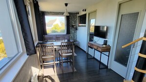 Una cocina moderna con comedor, televisor y un amplio ventanal.