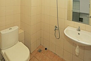 Une petite salle de bain avec des toilettes, un lavabo et une douche.