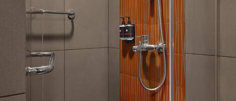 A modern shower with a wooden panel wall, a handheld showerhead, and a handheld shower attachment.