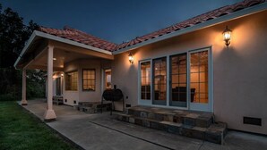 A two-story house with a covered patio, large windows, and a barbecue grill. - Guinda's Finest Nature Get-Away! (Guinda)