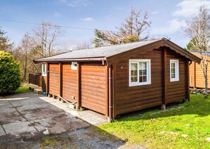 Une cabane en bois avec un toit en pente, un petit porche et le numéro « 121 » peint sur le côté.