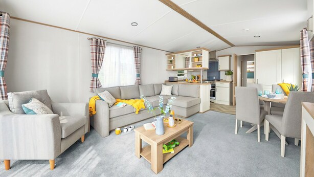 En moderne stue med sofa, sofabord og spiseplads.