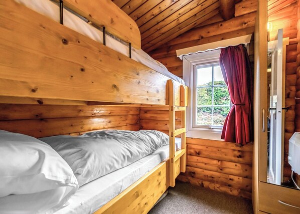 Dormitorio con literas, ventana y puerta.