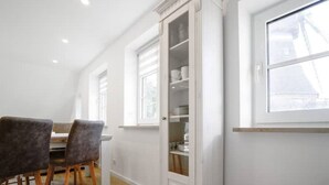 Ein geräumiges Zimmer mit Essbereich, einem Einbauschrank mit Regalen und einem großen Fenster.
