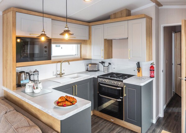 Een moderne keuken met een centraal eiland, een inbouwoven en een magnetron.