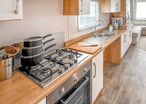 A modern kitchen with a gas stove, oven, and sink.