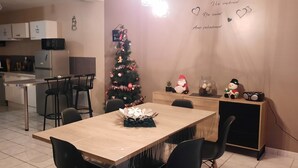 Eine moderne Küche mit Essbereich, einem Weihnachtsbaum und einem kleinen Tisch mit dekorativem Mittelstück.