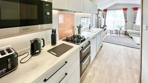 Eine moderne Küche mit Mikrowelle, Toaster, Wasserkocher und Gasherd.