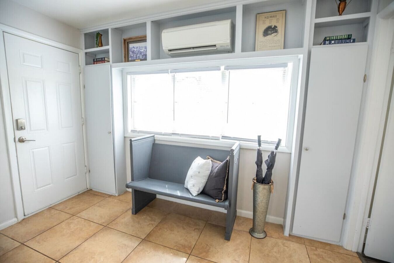 A room with a bench, a window, and a radiator.