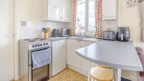 A compact kitchen with a stove, microwave, toaster, and air fryer. - 1 bedroom accommodation in Anderby Creek, Mablethorpe (Anderby Creek, Mablethorpe)