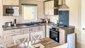 A modern kitchen with a microwave, toaster, sink, stove, and oven. - 1 bedroom accommodation in Tunstall, Nr Hull (Tunstall, Nr Hull)