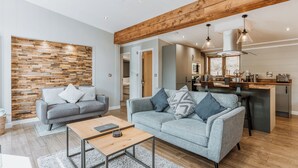 Un salon moderne avec deux canapés, une table basse et un mur d’accent en bois.