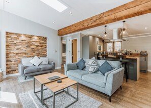 A modern living room with two sofas, a coffee table, and a wooden accent wall.