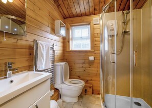 Puisesta mökistä löytyy kylpyhuone, jossa on wc, pesuallas ja suihku.