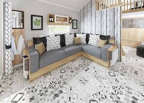 Un salon moderne avec un canapé d’angle, un meuble TV en bois et des carreaux de sol à motifs.