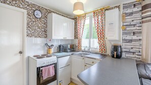 Una cocina compacta equipada con estufa, horno, microondas y cafetera.