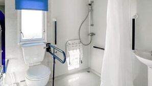 Kylpyhuone, jossa on wc, suihku, ikkuna ja pesuallas.