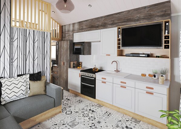 A modern kitchen with white cabinets, a black stove, and a large flat-screen TV.