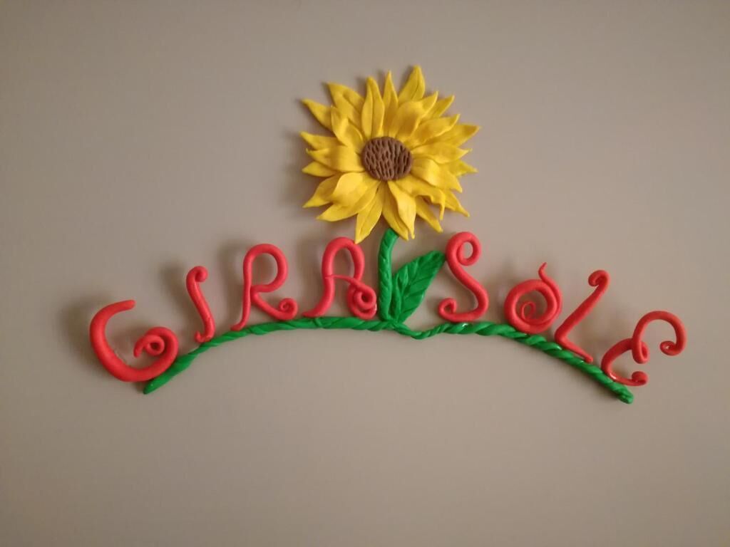 A decorative sign with the word "Girafe" and a sunflower.