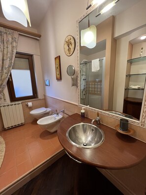 A bathroom with a vanity, two sinks, a mirror, a shower, and a toilet. - Il Sorriso Di Liu (Agrigento)