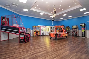 A room with arcade games, a basketball hoop, and a red play structure. - Lovely Beach View 3BR,King,Pool,P143 (Myrtle Beach)