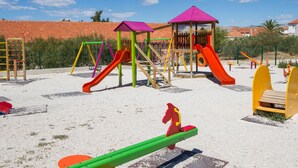 Une aire de jeux dotée de diverses installations, notamment des toboggans et des balançoires.