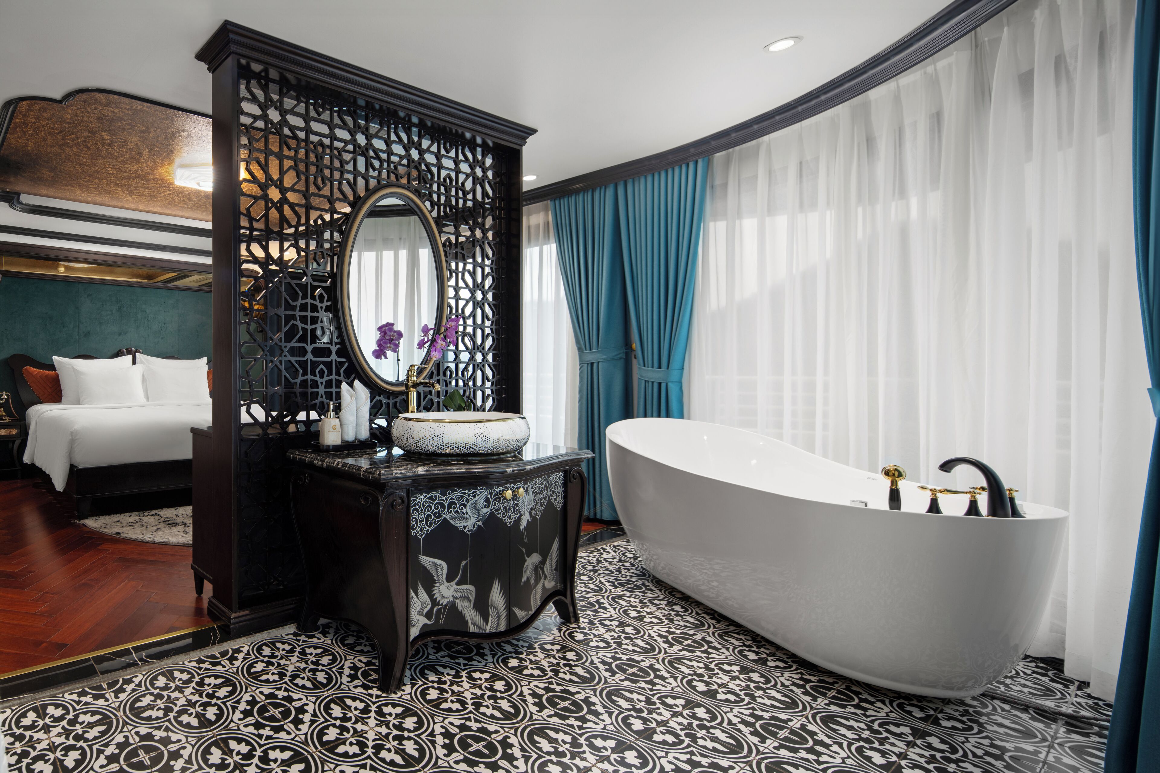 Un baño moderno con una bañera independiente, un espejo grande y un panel decorativo en la pared.