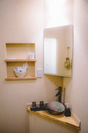 A bathroom with a sink, mirror, and shelves with toiletries. - Stay without meals Close to Kin no Yu Enjoy an  / Kobe Hyōgo (Kobe)