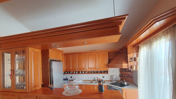 Une cuisine avec des meubles de rangement en bois, un réfrigérateur, une cuisinière et un évier.