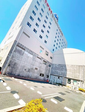 Hotel with a sleek, modern design and ample parking area.