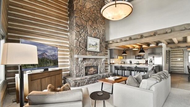 A modern living room with a stone fireplace, a television, and a sofa.