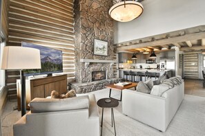 A modern living room with a stone fireplace, a television, and a sofa.