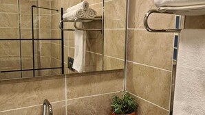 A bathroom with a white sink, a mirror, and a towel rack. - Ekin Otel (Fethiye)