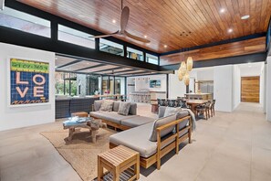 A spacious living area with a modern design, featuring a large sofa set, wooden coffee table, and a ceiling fan. - Rancho Alegre (Los Almendros, Hacienda Pinilla)