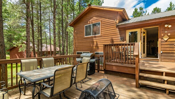 A wooden cabin with a deck, outdoor seating, and a grill area. - Pet-friendly cabin in the pines, 2 decks w/grill, <10 to skiing (Angel Fire)