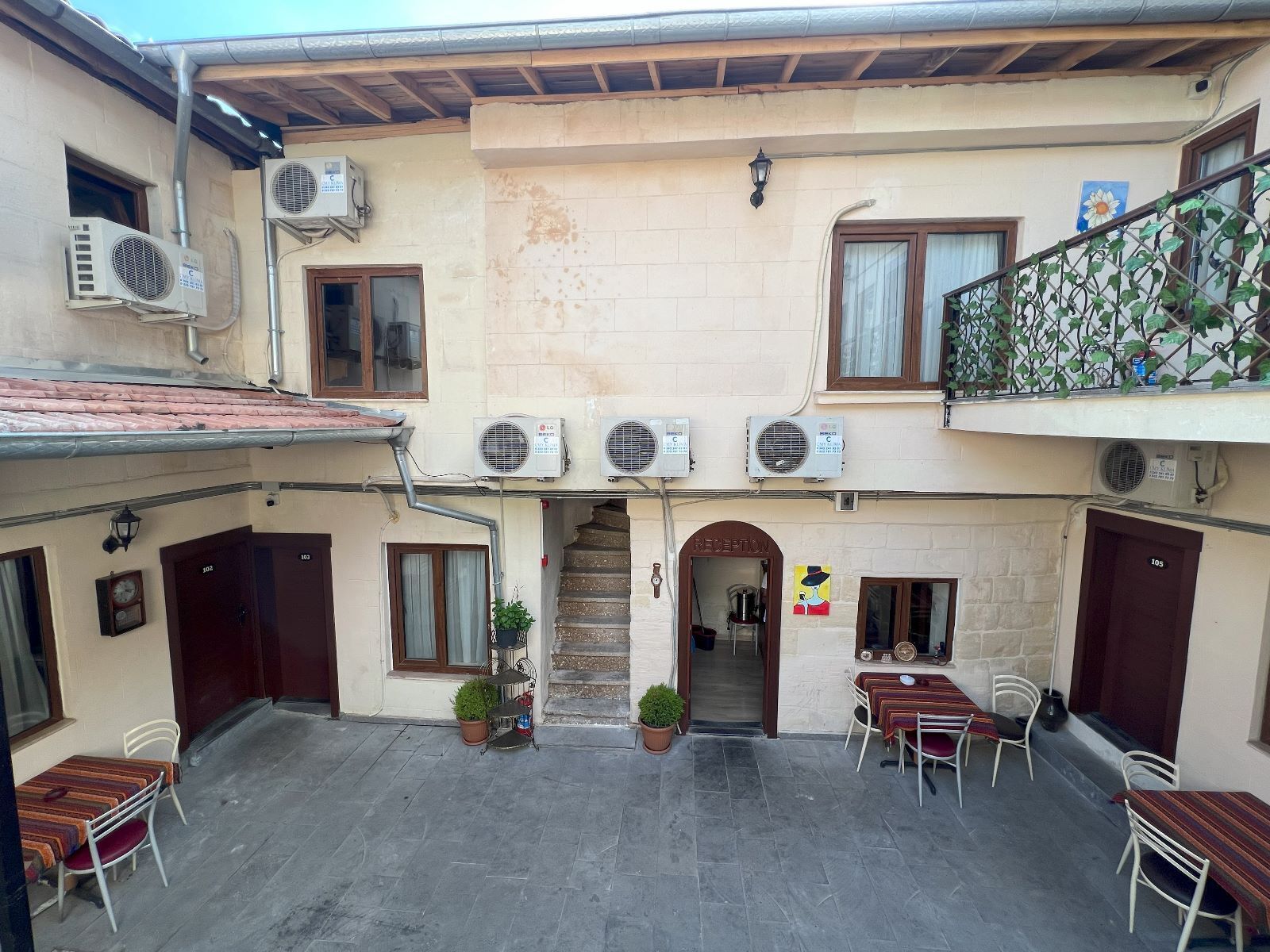 Un patio con mobiliario exterior, unidades de aire acondicionado y una zona de recepci ón.